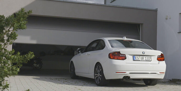 Car in front of an opening garage door